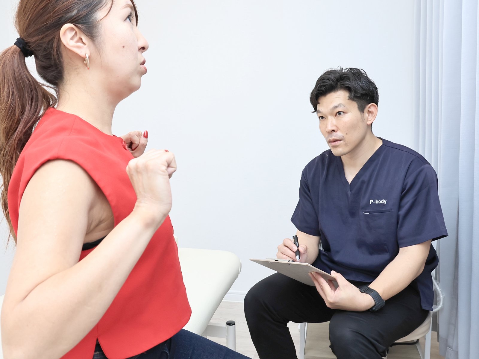 股関節の痛みについて問診する理学療法士
