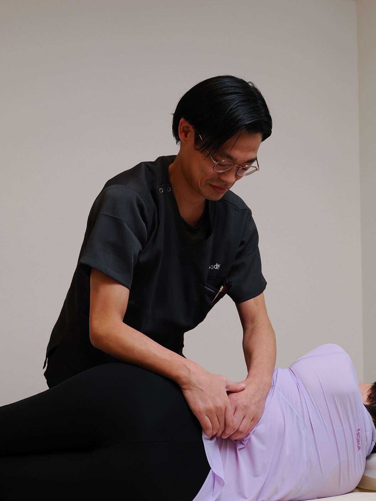 腰の状態を確認しながら施術する理学療法士