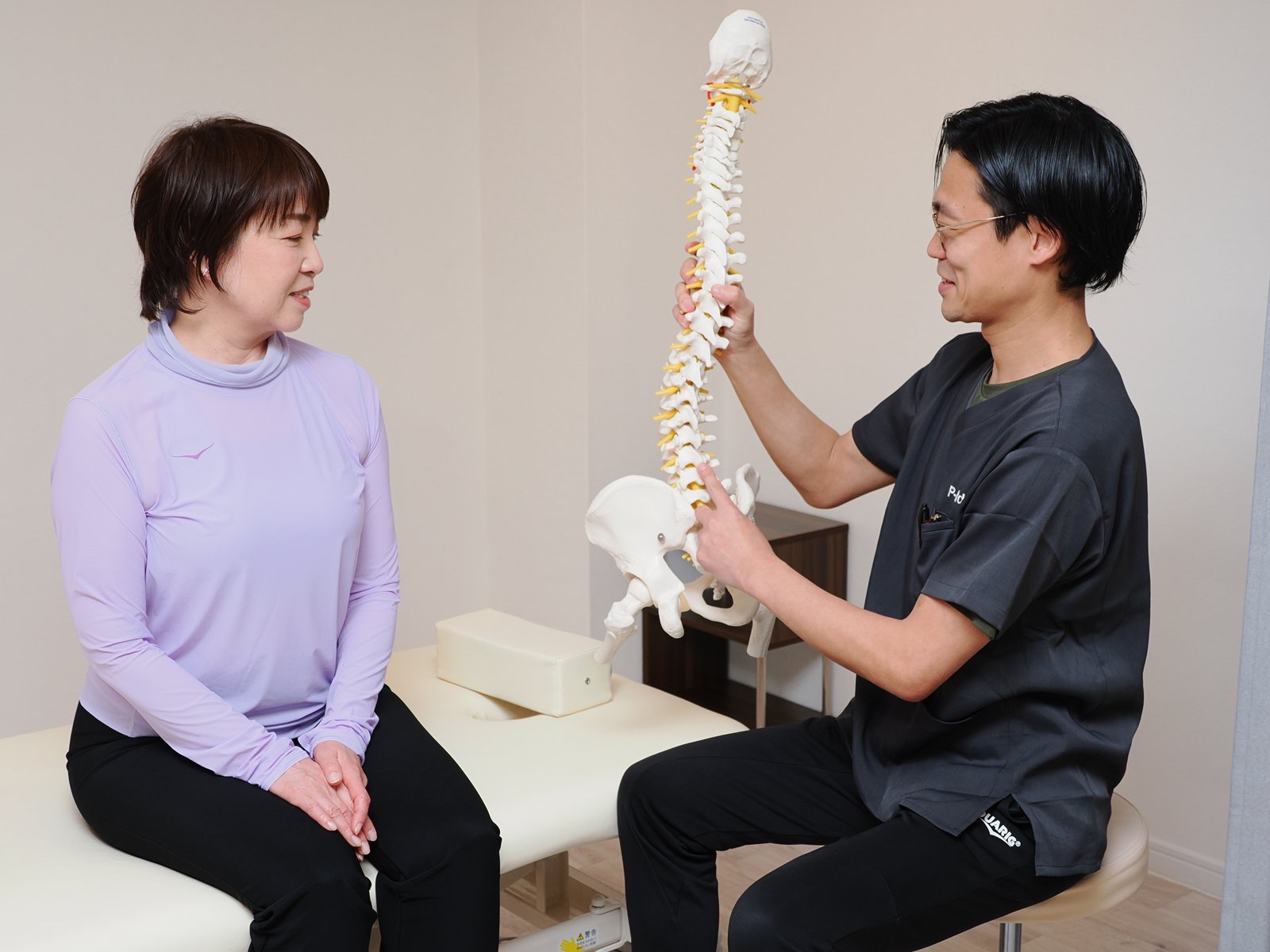 背骨の模型を使って腰の仕組みを説明する様子