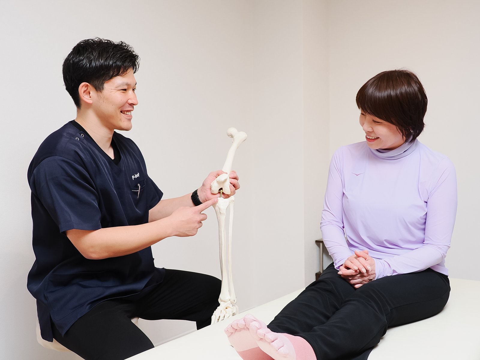 骨の模型を使って膝の仕組みを説明する様子